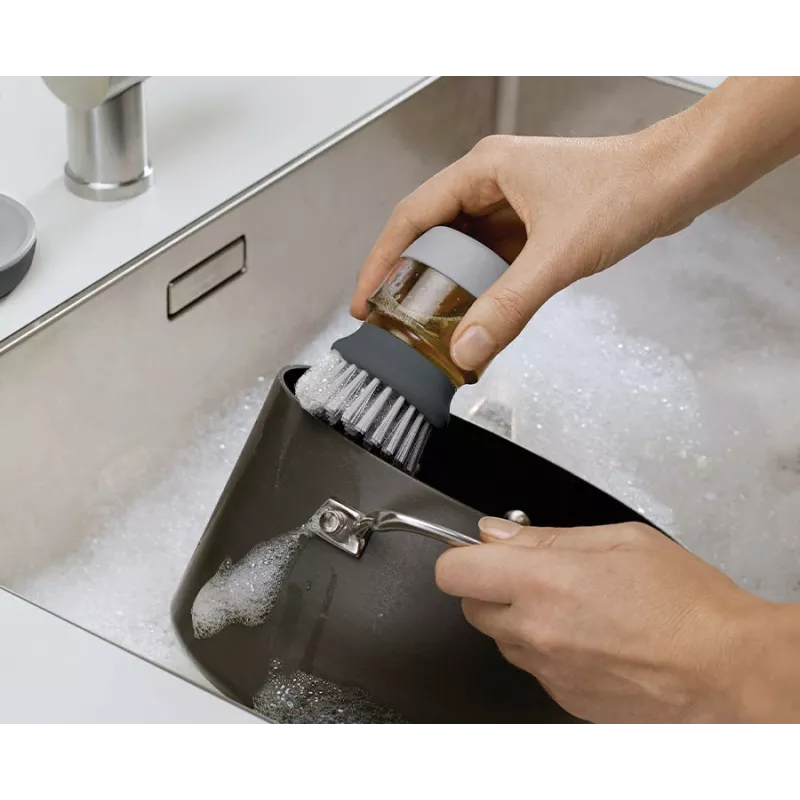 Joseph Joseph Palm Scrub Grey indų šepetys su integruotu muilo dozatoriumi