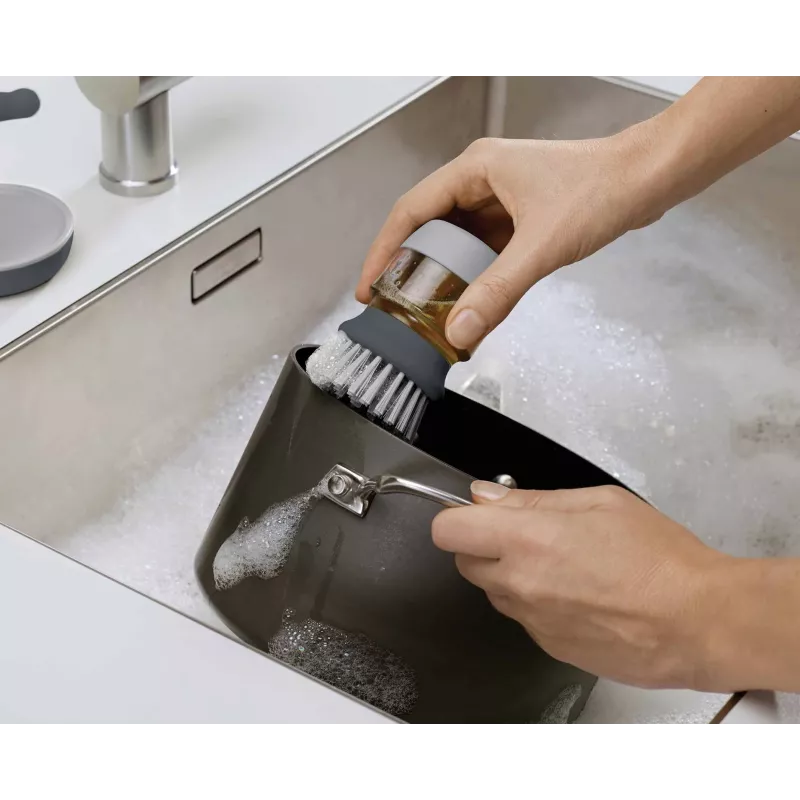 Joseph Joseph Palm Scrub Grey indų šepetys su integruotu muilo dozatoriumi